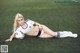 A woman laying on the ground with a soccer ball.