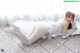 A woman laying on a bed in a white lingerie.