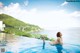 A woman in a white bikini sitting in a swimming pool.