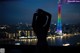 A woman standing in front of a city skyline at night.