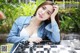 A woman sitting at a table with a chess board.