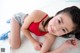 A young girl laying on a white rug with her legs crossed.